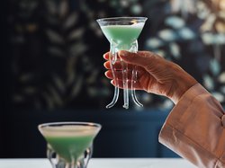 Hotel Latemar mit Dolomitenblick Zwei Gläser mit grünem Cocktail und eine schwebende Rauchblase