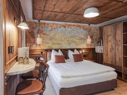 Hotel Latemar mit Dolomitenblick Schlafzimmer mit Doppelbett und rustikaler Holzeinrichtung