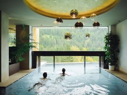 Hotel Latemar mit Dolomitenblick Personen im Innenpool mit Blick auf grüne Berge