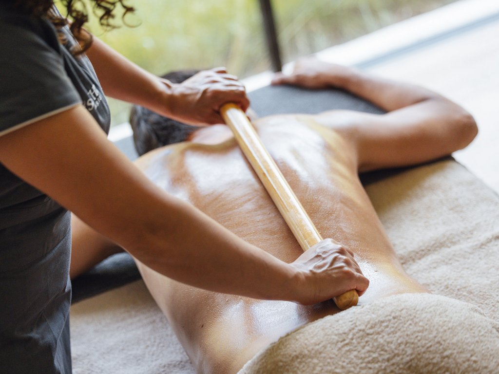 Hotel Latemar mit Dolomitenblick Rückenmassage mit Holzstab bei liegendem Mann
