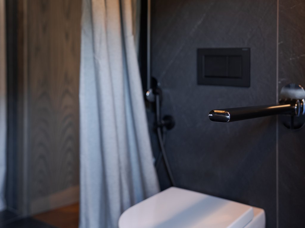 Hotel Latemar mit Dolomitenblick Schwarze digitale Waage an dunkler Wand neben Vorhang und weißem Möbelstück
