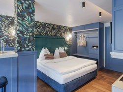 Hotel Latemar mit Dolomitenblick Modernes Schlafzimmer mit blauen Wänden und floralem Tapetenmuster