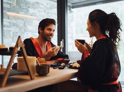Hotel Latemar mit Dolomitenblick Paar isst Sushi und trinkt Tee in schwarzen und roten Kimonos im Restaurant