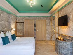 Hotel Latemar mit Dolomitenblick Modernes Schlafzimmer mit Doppelbett, dekorierten Wänden und Elektro-Kamin