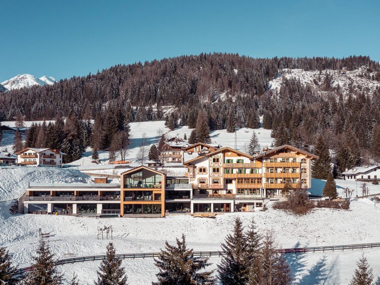 Hotel Latemar mit Dolomitenblick Alpenhotel im Winter mit Schnee und Wald vor Bergkulisse