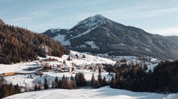 Hotel Latemar mit Dolomitenblick Winterlandschaft mit verschneitem Bergdorf