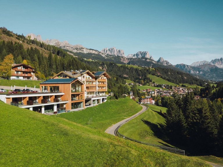 Hotel Latemar mit Dolomitenblick Modernes Hotel auf Hügel mit Blick auf schneebedeckte Berge und grünen Wald
