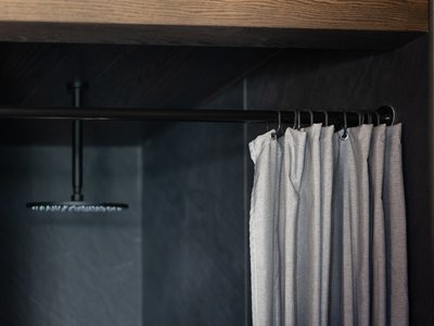 Barrierefreies Hotel im Val di Fassa: das Latemar Schwarze Dusche mit grauem Vorhang an Metallstange in modernem Bad