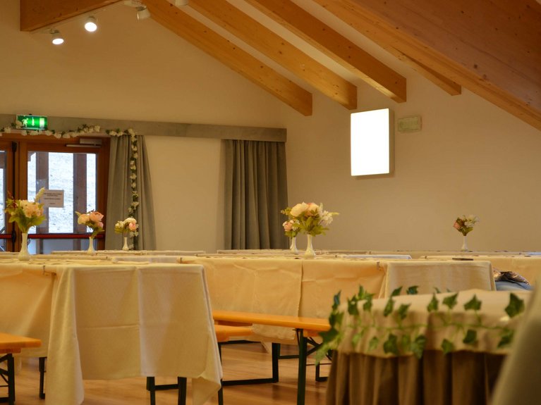On the webcam Latemar is lovely, in real life it’s a dream! Room with set tables and flower vases in a space with wooden beams