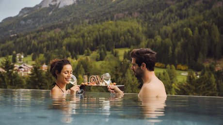 Picture gallery Couple drinking wine in pool with mountain view