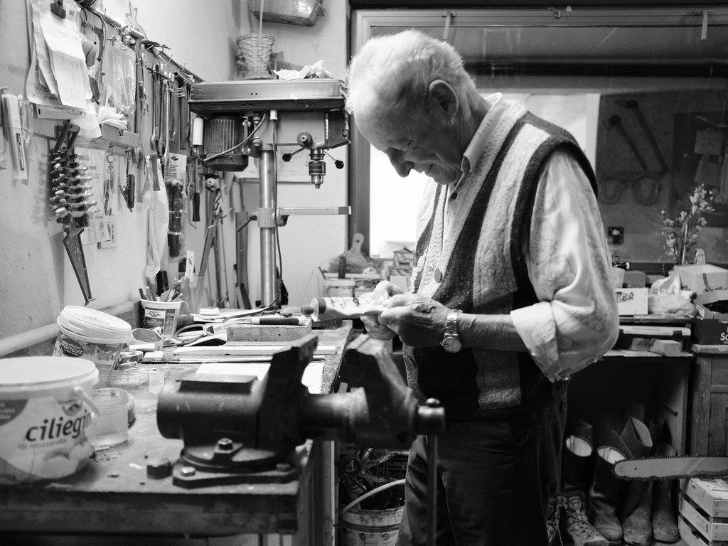 Hotel a Soraga: passione di famiglia Uomo anziano che lavora in una bottega con attrezzi e utensili