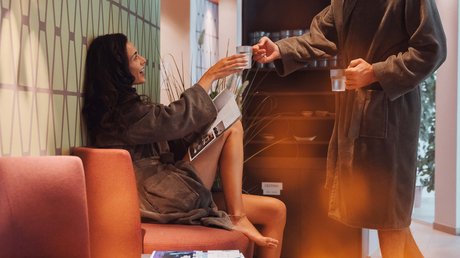 Meteo, Moena, Soraga, Latemar: tutto nella nostra gallery Coppia in accappatoi che si scambiano bicchieri d'acqua in un'area relax.