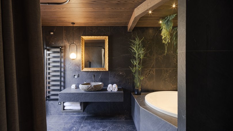 Moena: Unterkunft für Ihren Traumurlaub. Hotel Latemar! Modernes Badezimmer mit runder Badewanne, steinwaschbecken und grünen Pflanzen