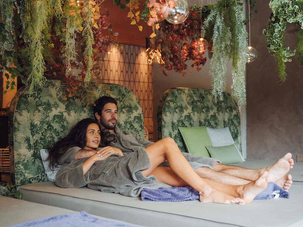 Trentino: Hotel am See mit Pool und Spa Entspanntes Paar auf Liegen im Spa mit hängenden Pflanzen