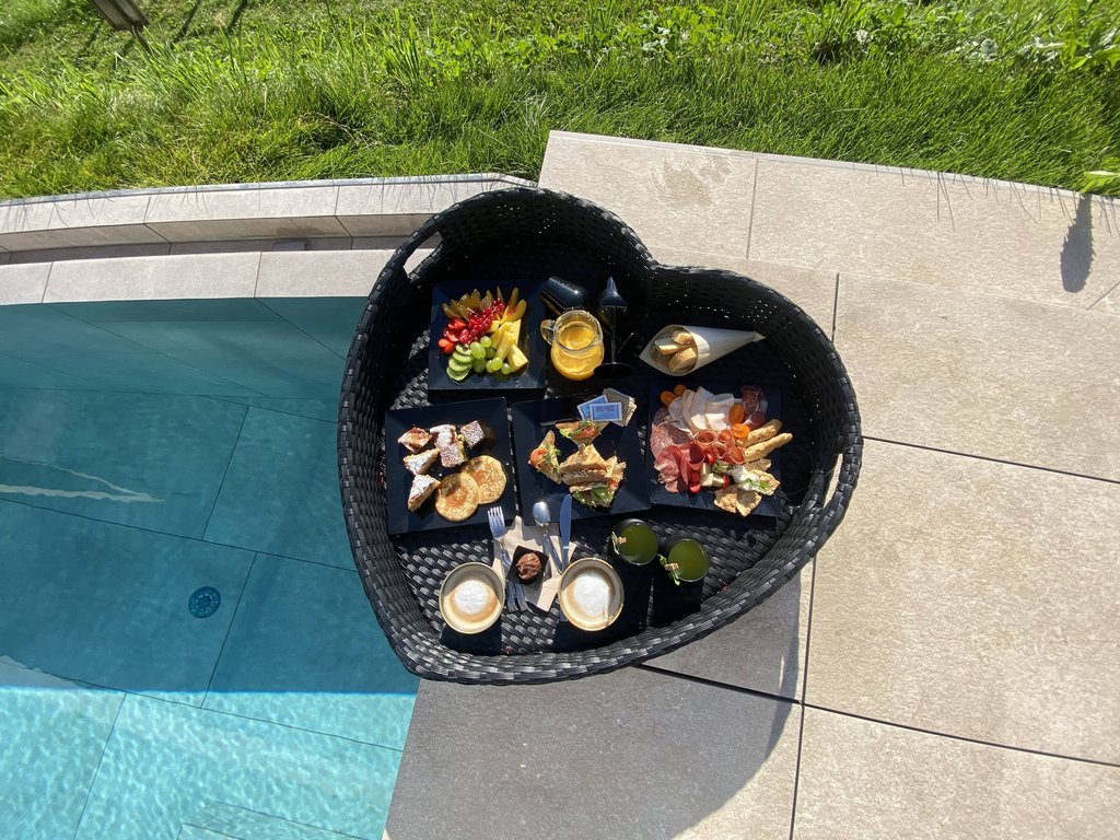 Sulla pista ciclabile, da Moena alla vostra oasi romantica Cesto a forma di cuore con colazione assortita a bordo piscina