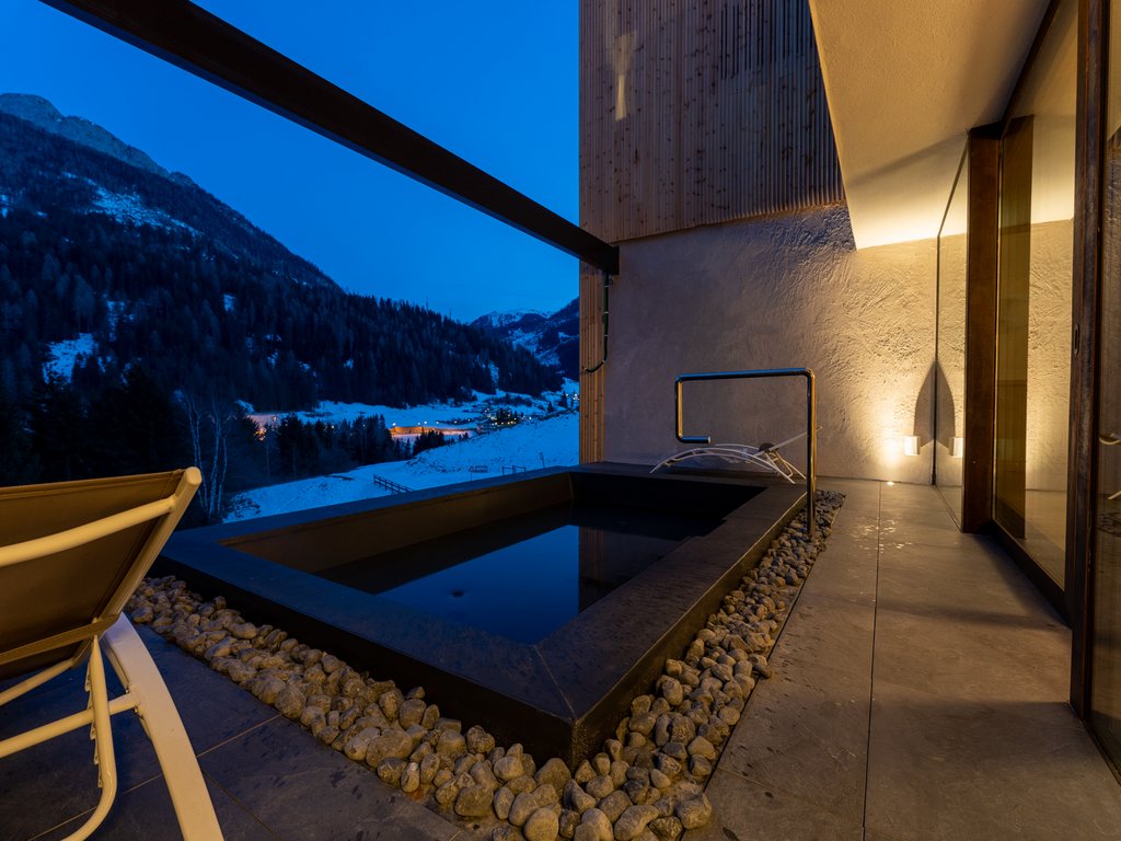 Urlaub im Fassatal: Erholung pur Außen-Thermalbecken mit Panoramablick auf Berge bei Abenddämmerung