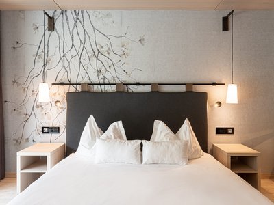 Hotel a Soraga in Val di Fassa: camere & suites Camera da letto moderna con letto matrimoniale, comodini e lampade a sospensione