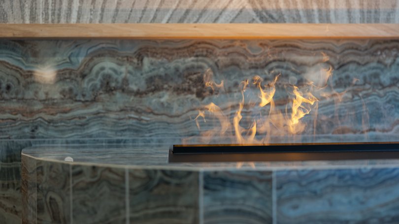 Moena: Unterkunft für Ihren Traumurlaub. Hotel Latemar! Moderner Marmorkamin mit sichtbaren Flammen im Vordergrund