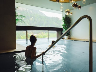 Barrierefreies Hotel im Val di Fassa: das Latemar Zwei Frauen entspannen im Innenpool mit Bergblick