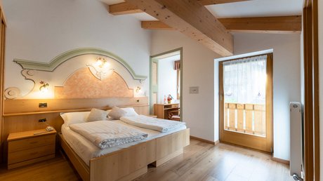 Picture gallery Bedroom with double bed, wooden beam ceiling, and balcony