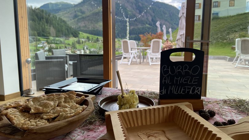 Val di Fassa: wandern, biken, erleben Brot und Honigbutter vor Berglandschaft im Hintergrund