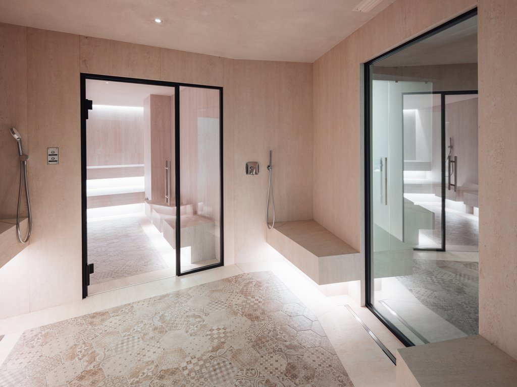 Trentino: Hotel am See mit Pool und Spa Innenraum eines modernen Spabereichs mit hellen Wänden und Mosaikboden