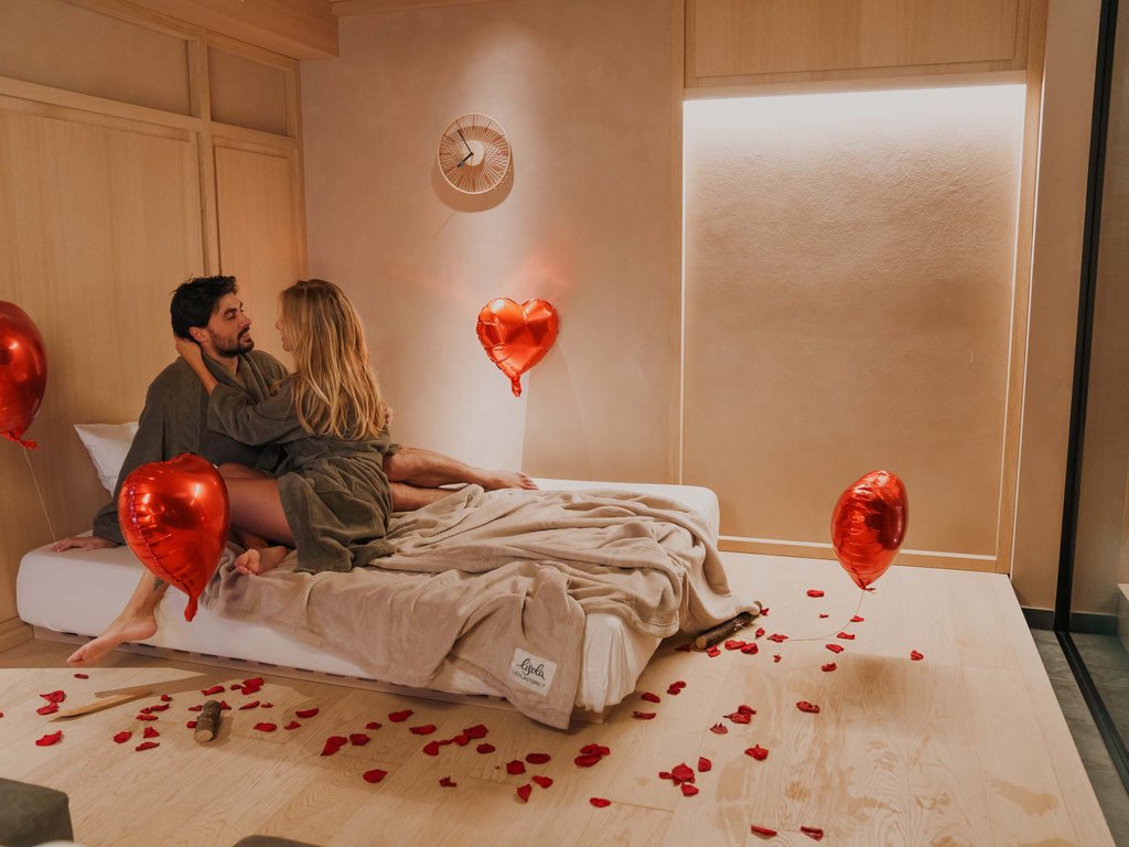 Soraga: dal lago alla piscina del Latemar Coppia romantica su letto con palloncini a forma di cuore e petali rossi
