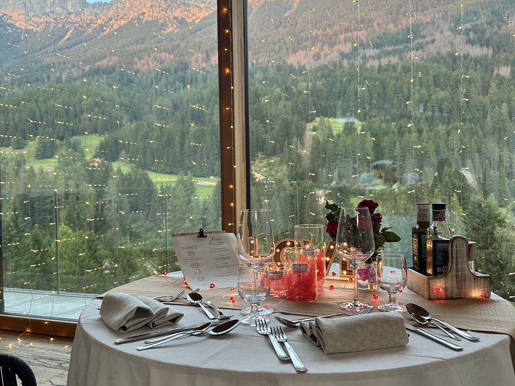 In Soraga, the weather is always right for a day spa! Set dining table with mountain view through large window