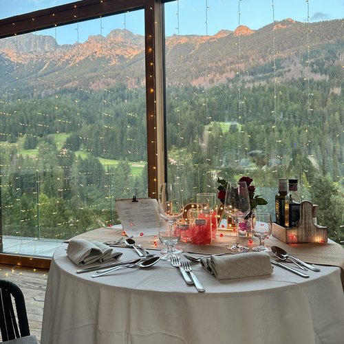 Restaurant Mirage mit Dolomiten-Blick im Fassatal Eingedeckter Tisch mit Bergblick durch großes Fenster
