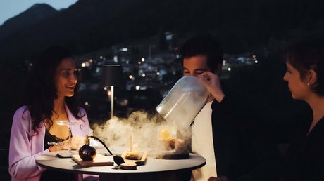 Meteo, Moena, Soraga, Latemar: tutto nella nostra gallery Tre persone a un tavolo all'aperto di sera con montagne sullo sfondo