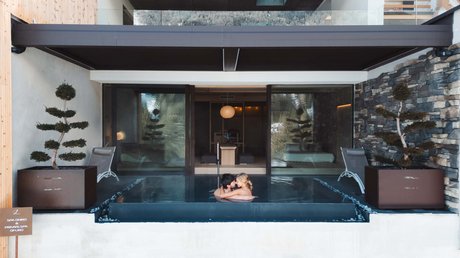 Picture gallery Couple embracing in a private outdoor pool at a modern hotel