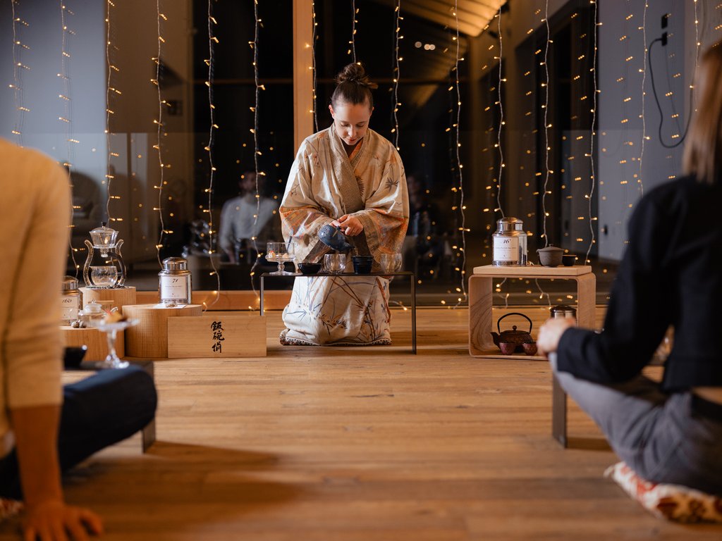 Val di Fassa and cycle track: outside our cocktail & tea bar Woman in kimono conducting Japanese tea ceremony with two people seated nearby.