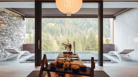Picture gallery dining room overlooking pool and forest through large window