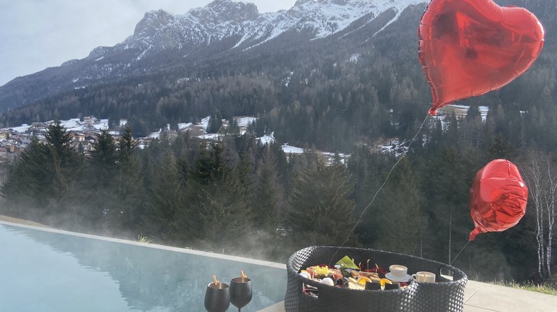 A Soraga il meteo è sempre ottimo per un Day Spa! Piscina all'aperto con vista sulle montagne e cesto con cibo e palloncini a forma di cuore
