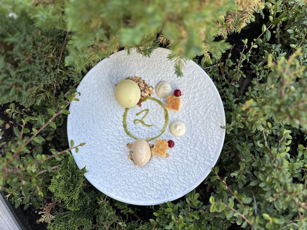 Ristorante a Soraga di Fassa: Mirage con #latermarview Dessert gourmet con gelati e decorazioni su piatto bianco