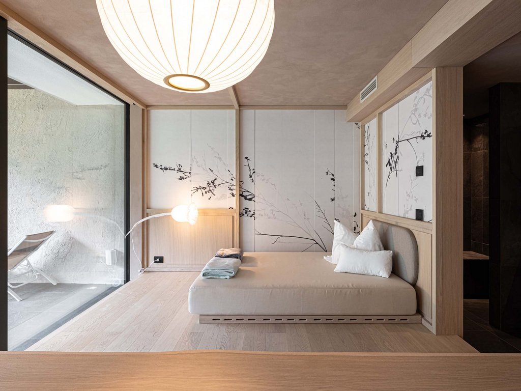 Soraga: dal lago alla piscina del Latemar Camera moderna con letto minimalista, lampada e pareti decorate