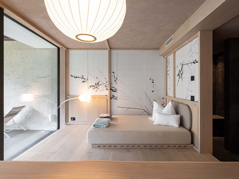 Urlaub im Fassatal: Erholung pur Modernes Zimmer mit minimalistischem Bett, Lampe und dekorierten Wänden