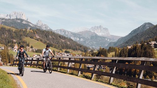 Fassatal: Radweg für romantische Momente Zwei Radfahrer auf einer Bergstraße mit Alpenlandschaft