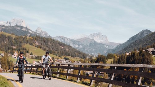 Hotel Latemar: richiesta Due persone in bici su una strada di montagna con paesaggio alpino