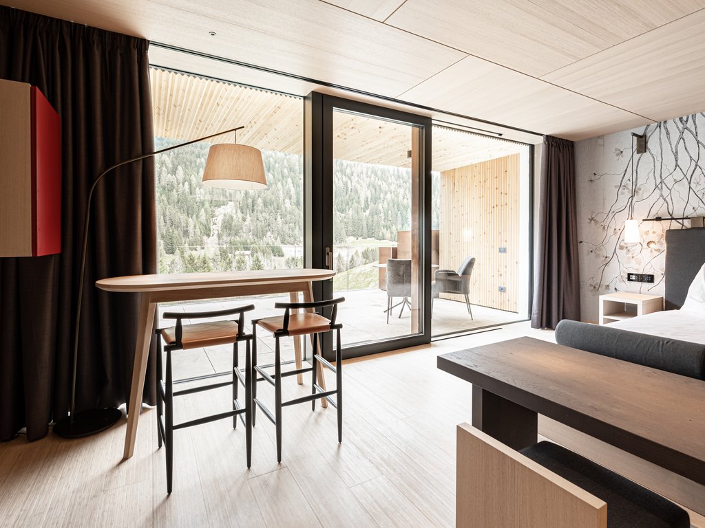 Hotel Latemar con vista sulle Dolomiti Interno di una stanza moderna con tavolo, sedie e balcone con vista sulle montagne