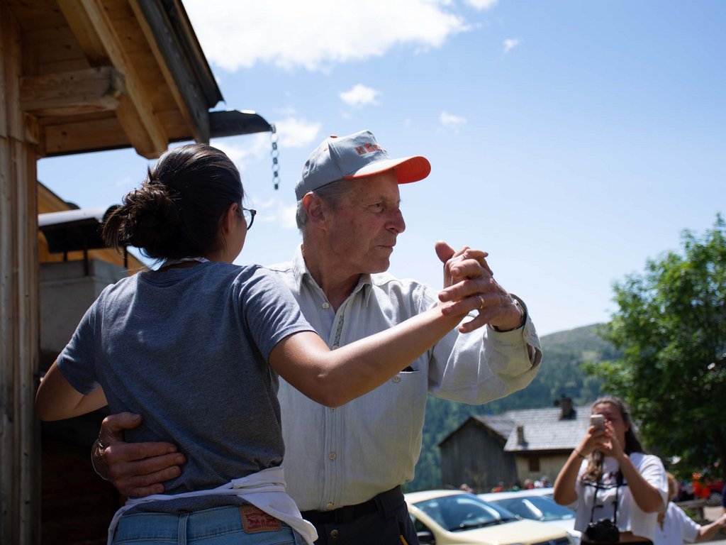 Per buongustai: l’hotel ideale vicino a Moena Uomo anziano e giovane donna che ballano all'aperto in una giornata soleggiata