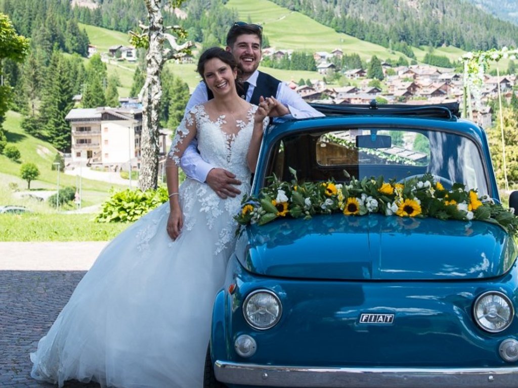 On the webcam Latemar is lovely, in real life it’s a dream! Bride and groom next to a flower-decorated vintage Fiat with mountain landscape background