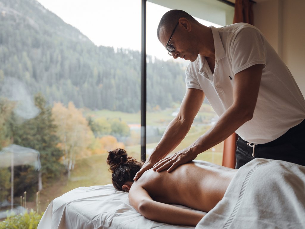 Soraga: dal lago alla piscina del Latemar Massaggiatore che fa un massaggio alla schiena in una stanza con vista sulla montagna