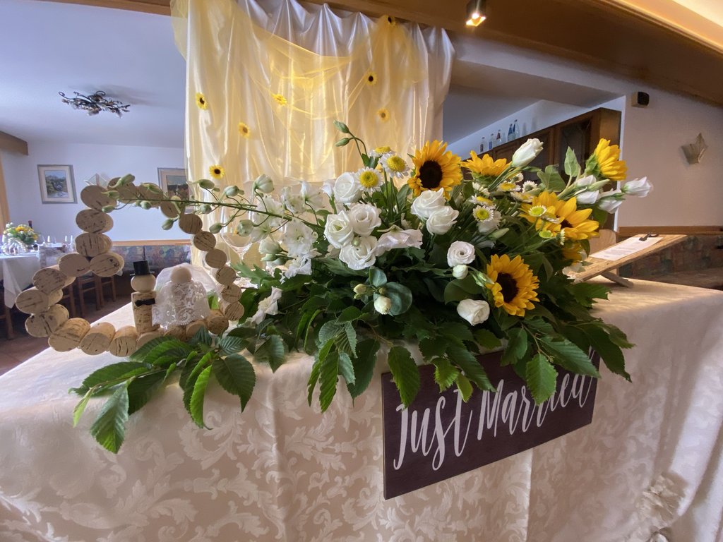 Dalla webcam il Latemar è bello, ma dal vivo è un sogno! Composizione floreale e decorazioni per matrimonio con cartello just married