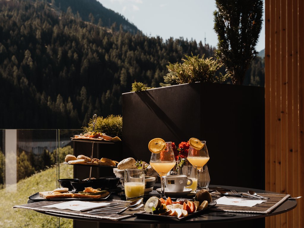 Soraga bei Südtirol im Trentino Frühstück mit Saft, Obst und Gebäck auf Terrasse mit Bergblick