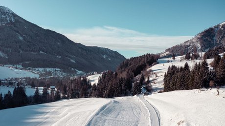 Meteo, Moena, Soraga, Latemar: tutto nella nostra gallery Paesaggio invernale con strada innevata tra montagne e alberi.