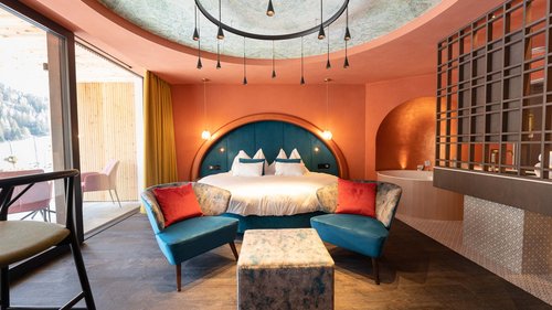 Suite Petite Lumière Camera da letto moderna con poltrone blu, letto tondo e ampio finestrone