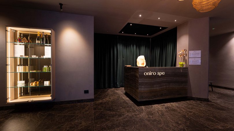 Moena: Unterkunft für Ihren Traumurlaub. Hotel Latemar! Moderner Spa-Empfang mit Produktvitrine und warmem Licht