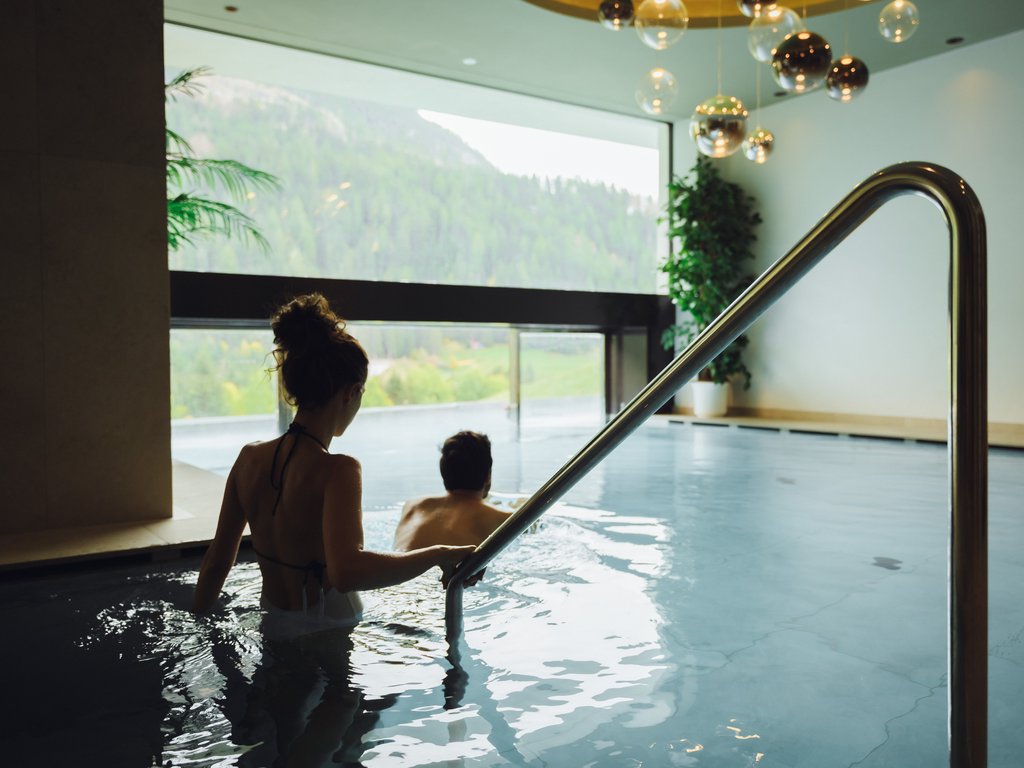 Hotel Latemar con vista sulle Dolomiti Coppia entra in una piscina interna con vista sulle montagne