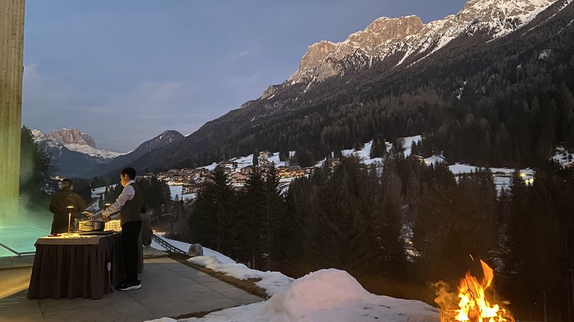 Escursioni da Moena e molto altro: il nostro programma Persone accanto a un tavolo con cibo su una terrazza innevata con vista montagne